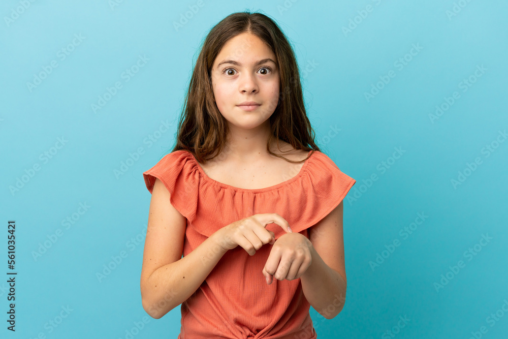 Obraz premium Little caucasian girl isolated on blue background making the gesture of being late