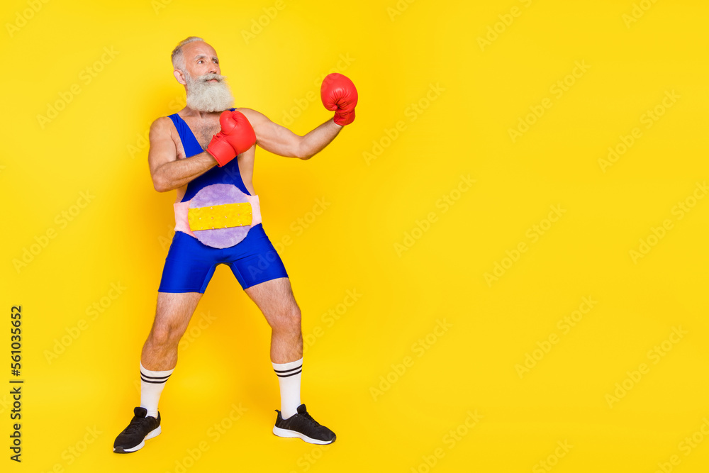 Full size photo of serious strong grandfather hands boxing gloves fighting empty space isolated on yellow color background