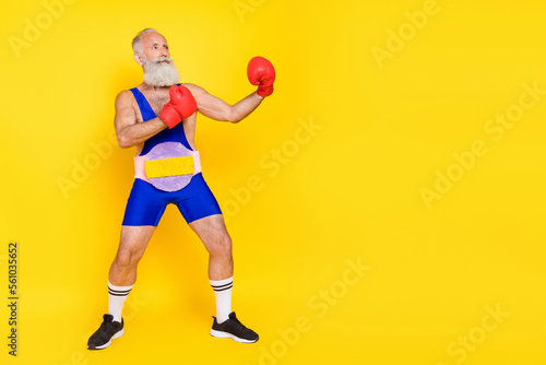 Fototapeta Naklejka Na Ścianę i Meble -  Full size photo of serious strong grandfather hands boxing gloves fighting empty space isolated on yellow color background