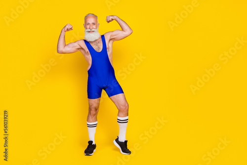 Full body length photo of old age pensioner man gray long beard posing wear blue sport costume showing biceps isolated on yellow color background © deagreez