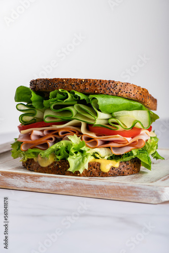 High Closed Sandwich with wholemeal bread, cheese, ham, tomatoes, cucumber and letuce salad leaves