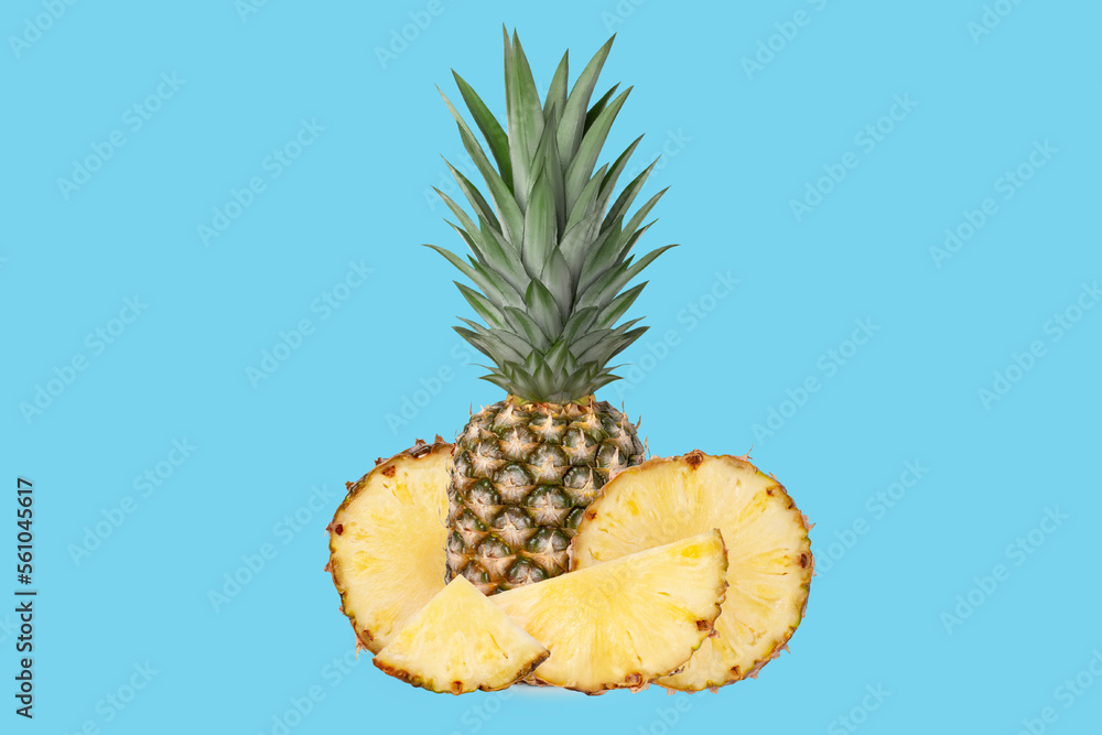 Whole juicy fresh pineapple. Pieces of pineapple in circles, rings, halves, quarters. on a blue background. Whole juicy fresh pineapple. Pieces of pineapple in circles, rings, halves, quarters. on a blue background.