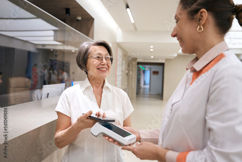 Fotografija Patient pays for her visit to the therapist