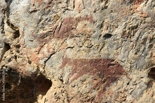 Ancient stone walls, brown and very old, with painted patterns on the surface.