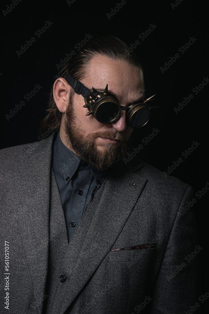 charismatic man in a classic suit and steampunk goggles on a black background stylish Portrait charismatic man in a classic suit and steampunk goggles on a black background stylish Portrait