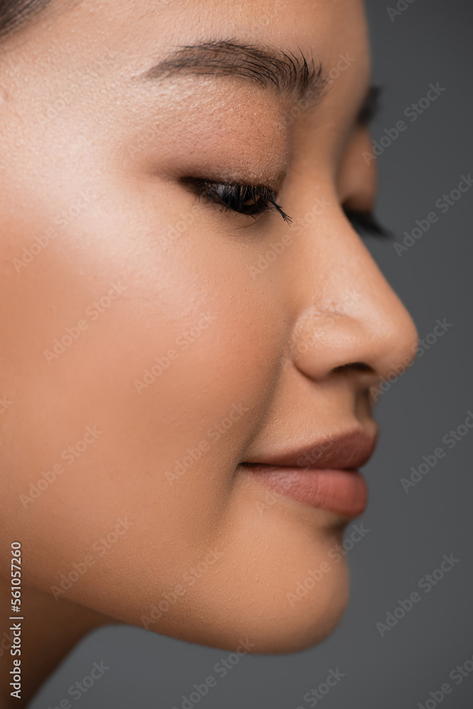 Close up view of young asian woman with makeup posing isolated on grey. Close up view of young asian woman with makeup posing isolated on grey.