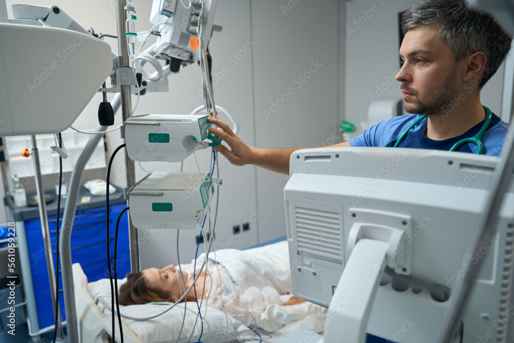 Nurse examining a patient in intensive care Nurse examining a patient in intensive care