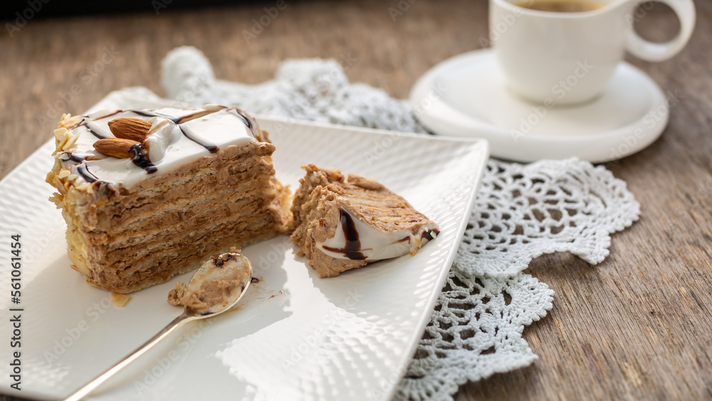 Piece of almond cake and white cup with tea