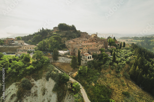 Small village of Chiusure on top of the hill surrounded by Karst cliffs landscape photographed with a drone. Toscana, Tuscany, Asciano, province of Siena in Italy with a little mud road 06.16.2021 © boumenjapet