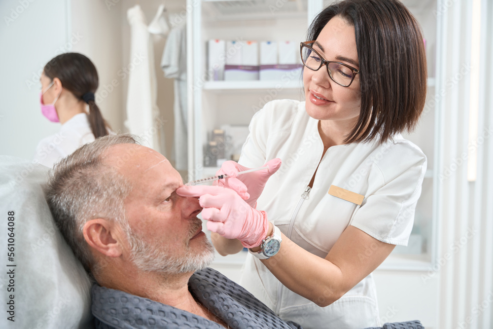Fototapeta premium Elderly man undergoes rejuvenating course with the use of fillers