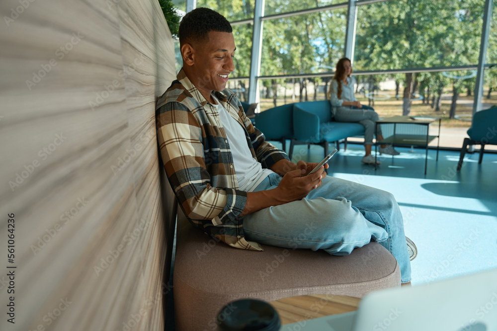 Smiling young man looking at mobile phone screen Smiling young man looking at mobile phone screen