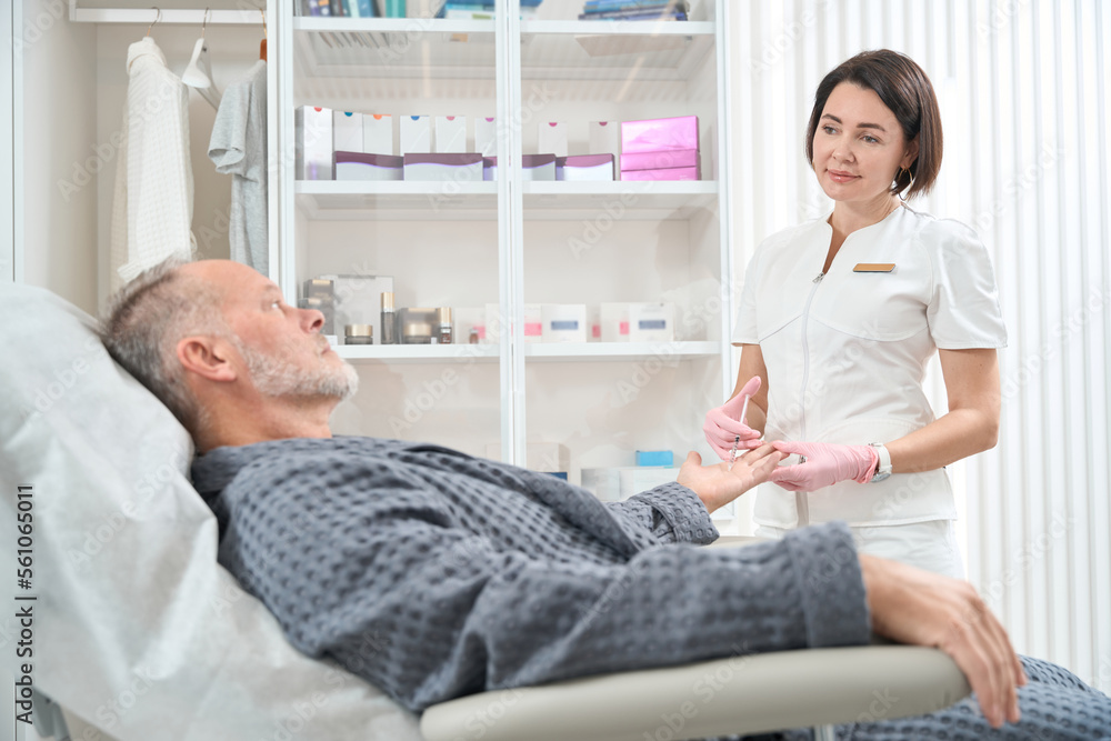 Obraz premium Pleasant female doctor makes injections from hyperhidrosis to a patient