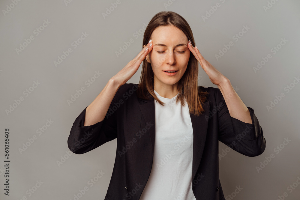 Young woman touches head while having a headache or thinking about something. Young woman touches head while having a headache or thinking about something.