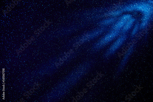 Light blue rays of light on a dark blue fine grained background