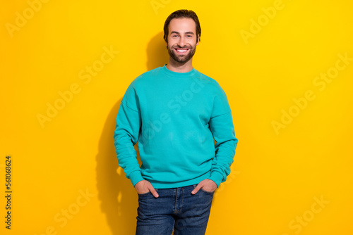 Photo of satisfied smiling glad successful entrepreneur influencer man stubble beard hands denim pockets isolated on yellow color background