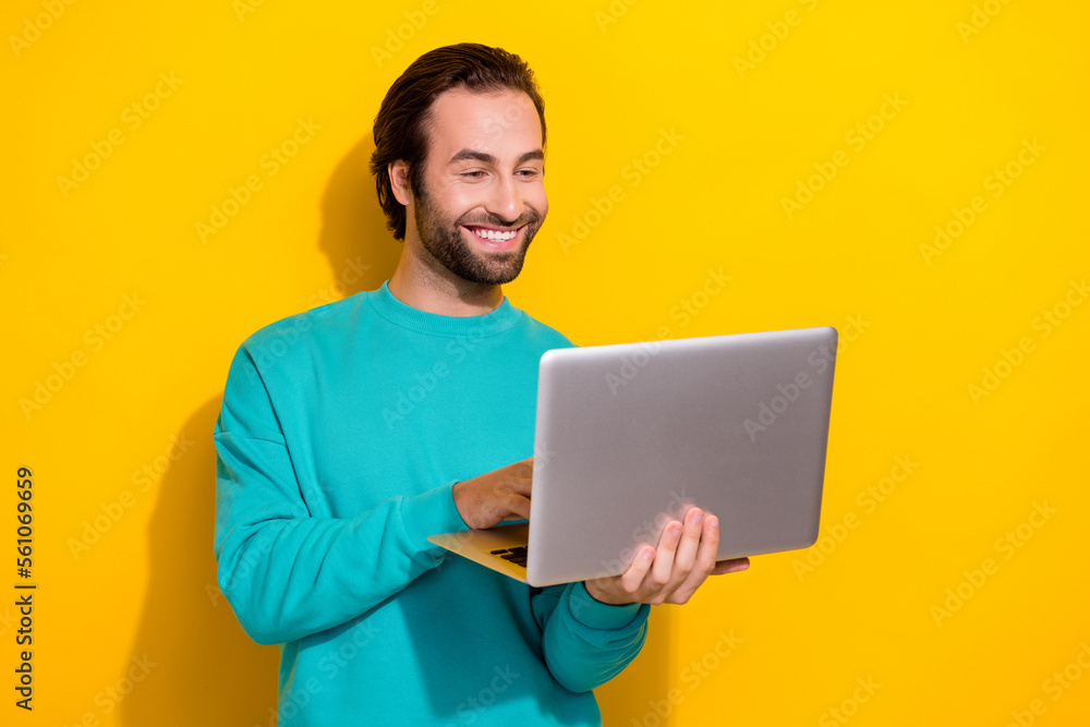 Photo of addicted programmer young student guy hold his computer netbook video conference with colleagues isolated on yellow color background Photo of addicted programmer young student guy hold his computer netbook video conference with colleagues isolated on yellow color background