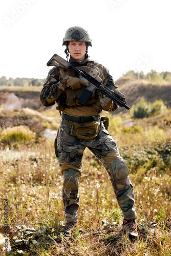Confident special forces soldier with rifle in field during military operation, portrait, alone. Concept of military anti-terrorism operations, special operations of NATO forces. guy in combat wear