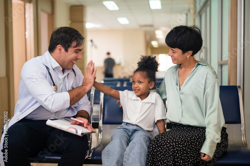 Pediatrician doctor examining child girl with her mother