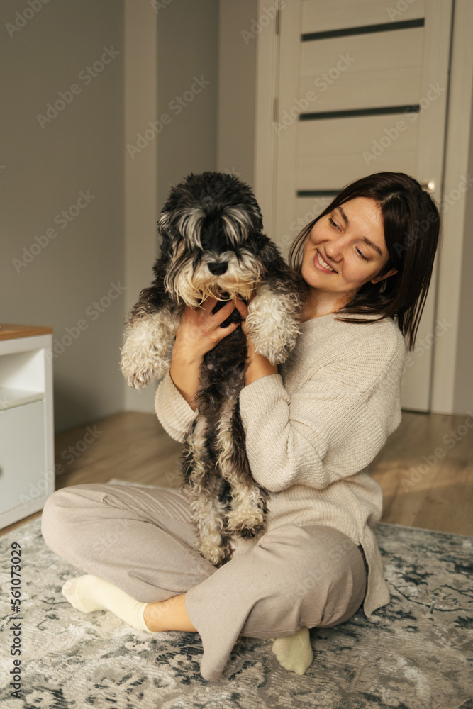 Beautiful caucasian woman with vitiligo hugging her dog miniature schnauzer breed at home. Friendship concept Beautiful caucasian woman with vitiligo hugging her dog miniature schnauzer breed at home. Friendship concept