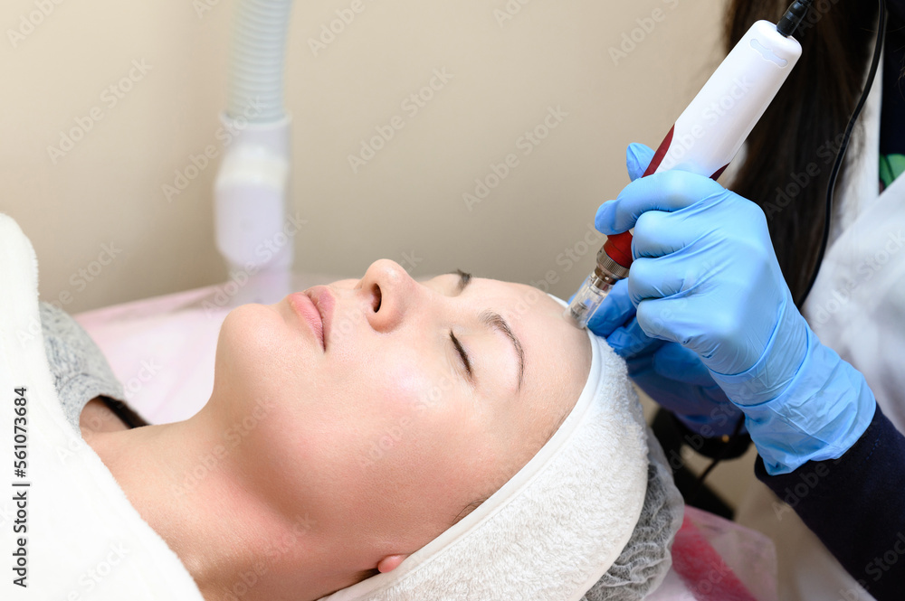 A beautician performs a rejuvenating mesotherapy procedure using dermapen. A beautician performs a rejuvenating mesotherapy procedure using dermapen.