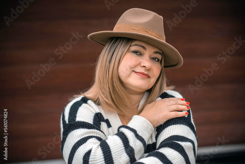Women psychology. Portrait of mature plus size lady in beige hat and striped sweater
