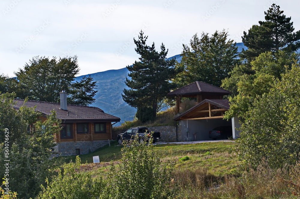 A scene with an autumn meadow, forest and part of a Bulgarian village in Plana Planina, Bulgaria  