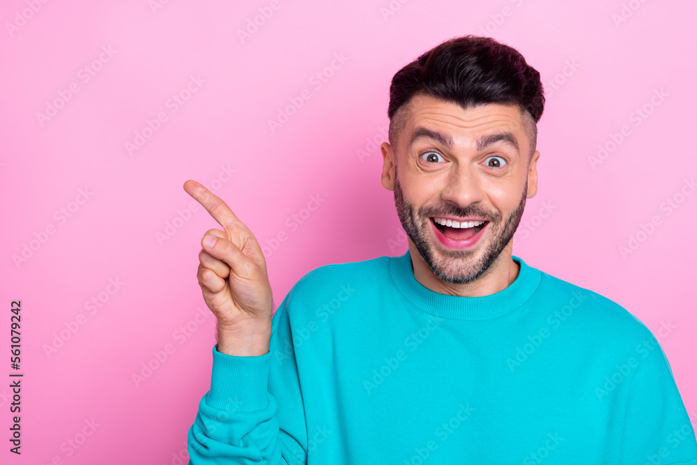 Photo of young promoter student guy wear stylish blue pullover direct finger mockup new brand open showroom ad isolated on pink color background Photo of young promoter student guy wear stylish blue pullover direct finger mockup new brand open showroom ad isolated on pink color background