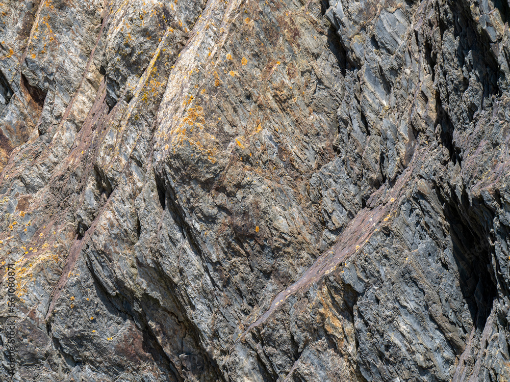 Naklejka premium A variety of geological strata as a background. Stone texture, full frame. Brown and gray rock formation