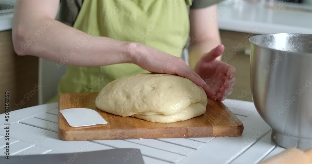 Unrecognisable male baker chef in green apron working with fresh proofed dough. Working at home kitchen concept, homemade baking. High quality 4k video footage Unrecognisable male baker chef in green apron working with fresh proofed dough. Working at home kitchen concept, homemade baking. High quality 4k video footage