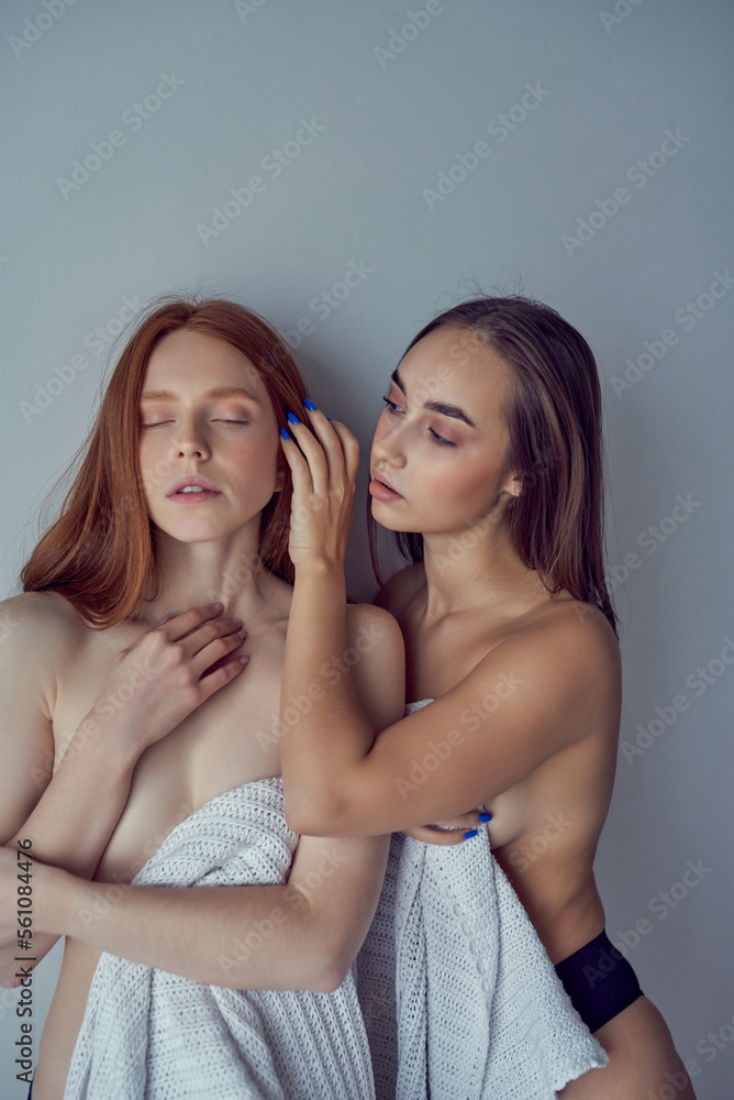 young women best friends wrapped in blanket, resting at home, relaxed in the morning. in cozy room, weekends holidays indoors. redhead and brunette ladies with slim body close to each other young women best friends wrapped in blanket, resting at home, relaxed in the morning. in cozy room, weekends holidays indoors. redhead and brunette ladies with slim body close to each other