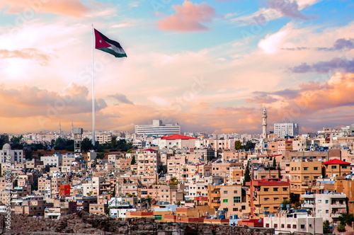 Photos Jordan flag in Amman, cloudy sky background with human houses urban