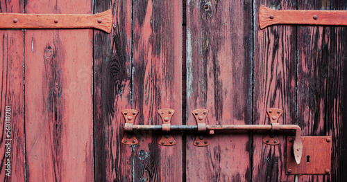 Rustic background. Detail of an ancient red door with a bar.