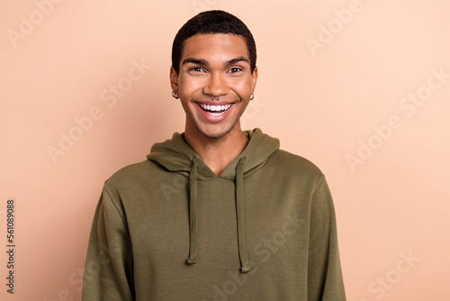 Photo of excited impressed guy dressed green khaki hoodie smiling isolated beige color background