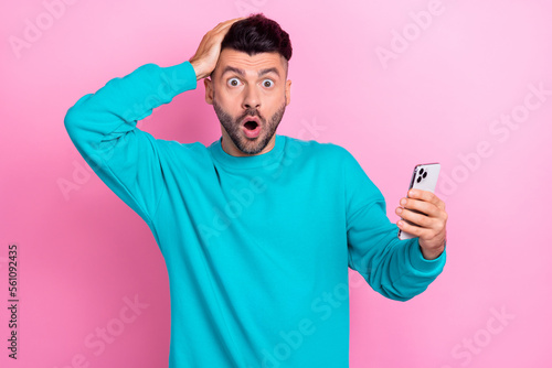 Photo of impressed man hand touch head open mouth staring use telephone isolated on pink color background