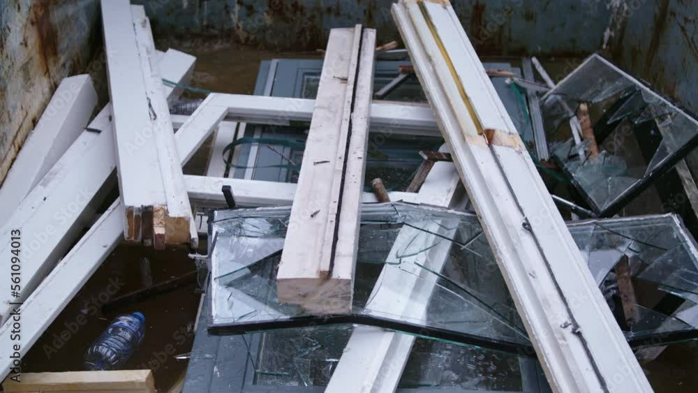 Window frames pieces falling into garbage dump. Window frames pieces falling into garbage dump.