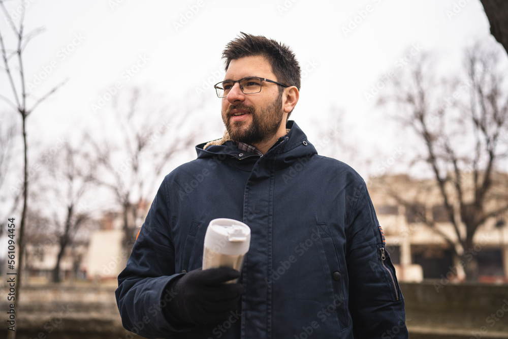 One man standing outdoor alone in winter day with cup of coffee One man standing outdoor alone in winter day with cup of coffee