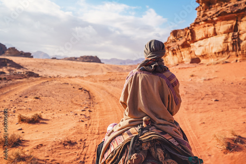 Photos Young woman riding camel in desert