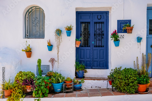 Pots with flowers next to a blue door in typical spanish village Frigiliana