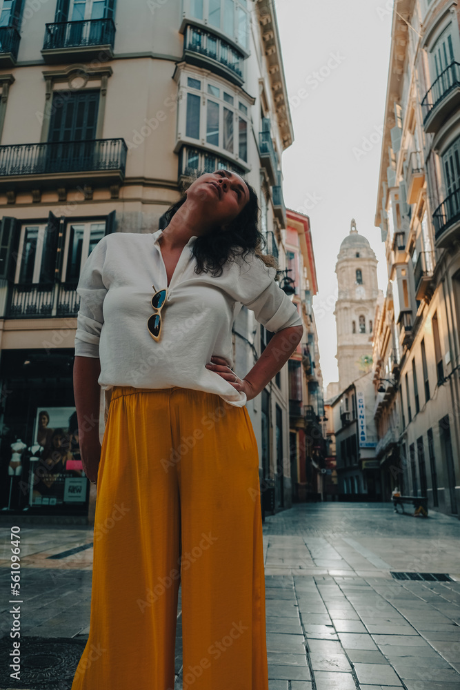 Woman in a street of Malaga, Spain, with a view of Cathedral at the back 