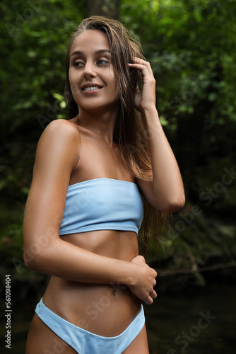Beautiful young woman in light blue bikini near mountain river outdoors © New Africa
