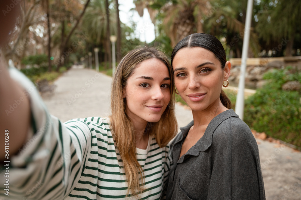 Two young women taking a selfie with her phone Two young women taking a selfie with her phone