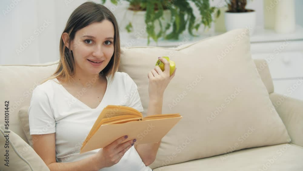 4k slowmotion video of pregnant woman looking at the camera with book and apple. 4k slowmotion video of pregnant woman looking at the camera with book and apple.