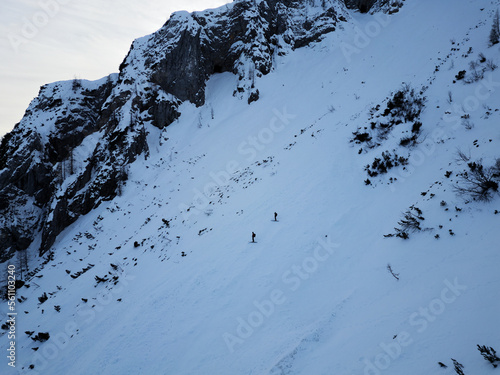 Aerial drone view of two skiers, free skiing down the mountain in the Triglav National Park. Julian Alps in Slovenia. Adrenaline sports and winter activities. Backcountry skiing or Alpine skiing. © stu.dio
