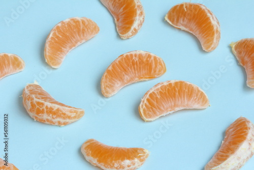 Peeled pieces of Clementine on a light blue background