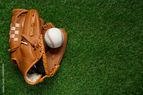 Photography Catcher's mitt and baseball ball on green grass, top view with space for text