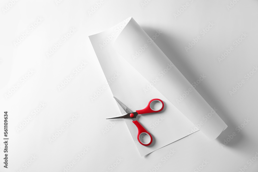Red scissors and paper on white background, top view. Space for text Red scissors and paper on white background, top view. Space for text