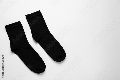 Pair of black socks on white background, flat lay. Space for text