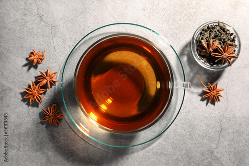 Aromatic tea with anise stars on light grey table, flat lay