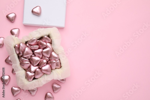 Box and delicious heart shaped candies on pink background, flat lay. Space for text © New Africa