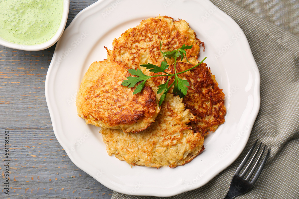 Tasty parsnip cutlets with parsley served on grey wooden table, flat lay